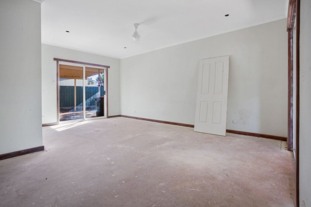 A room with a door open and sliding glass doors.