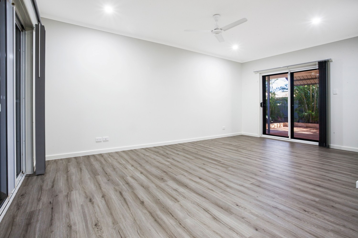 A room with white walls and wooden floors.