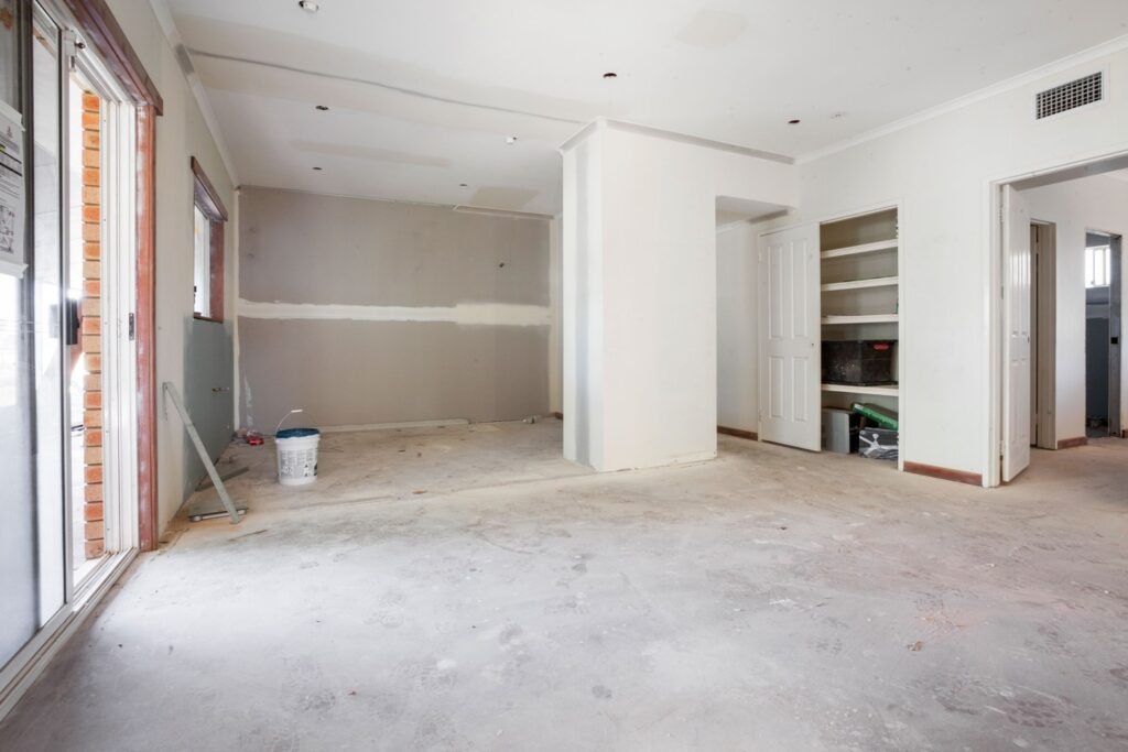 A room with walls and floors being remodeled.