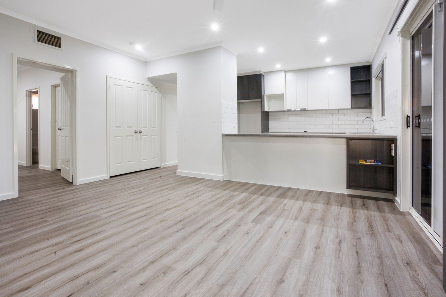 A room with white walls and wooden floors.