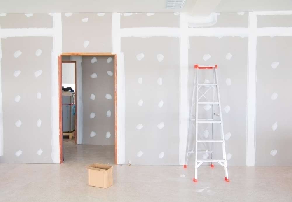 A ladder and box in the middle of a room.