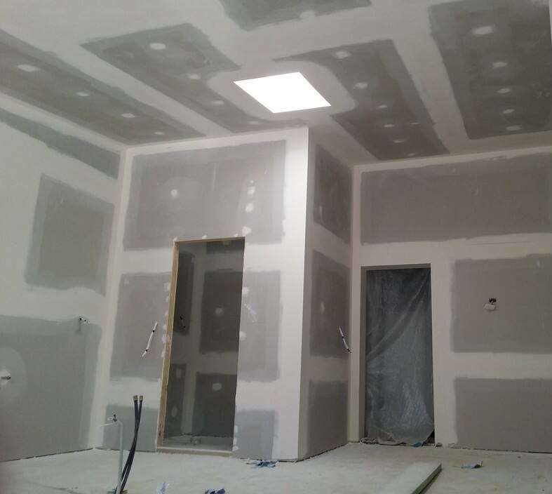 A room with walls and ceilings being remodeled.