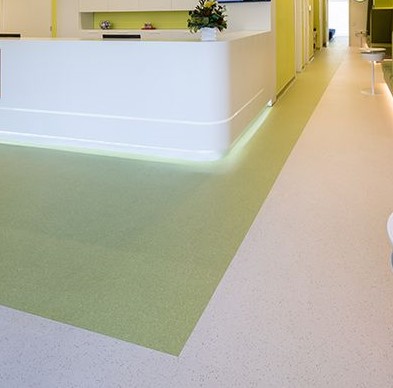 A white bathroom with yellow walls and green floor.