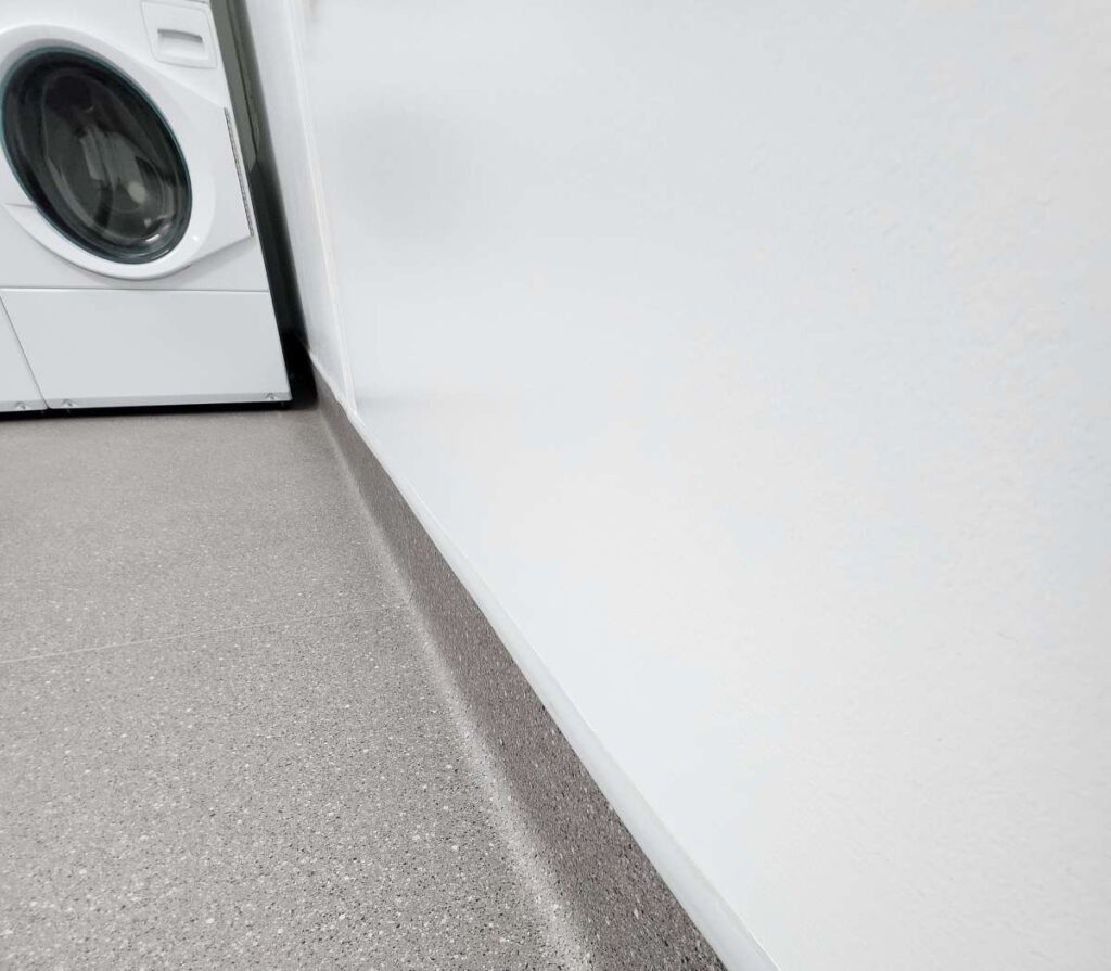 A white washer and dryer in the corner of a room.