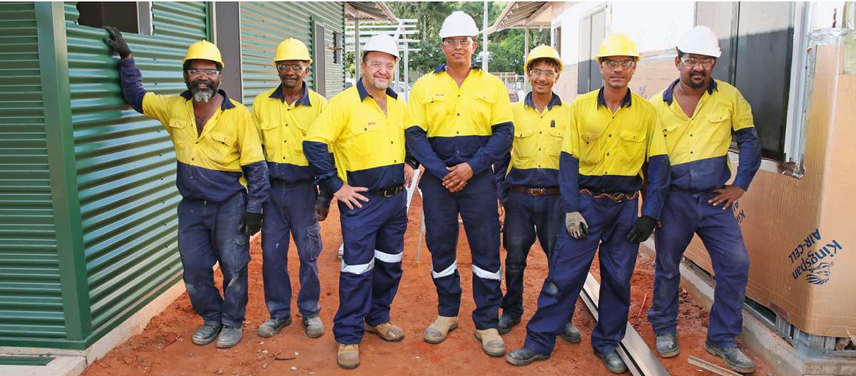 A group of men in yellow and blue work clothes.