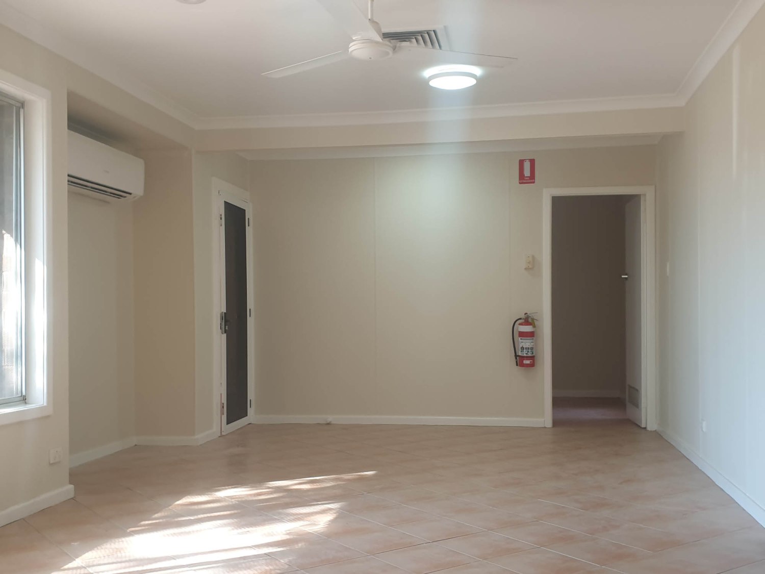 A room with a ceiling fan and a door.