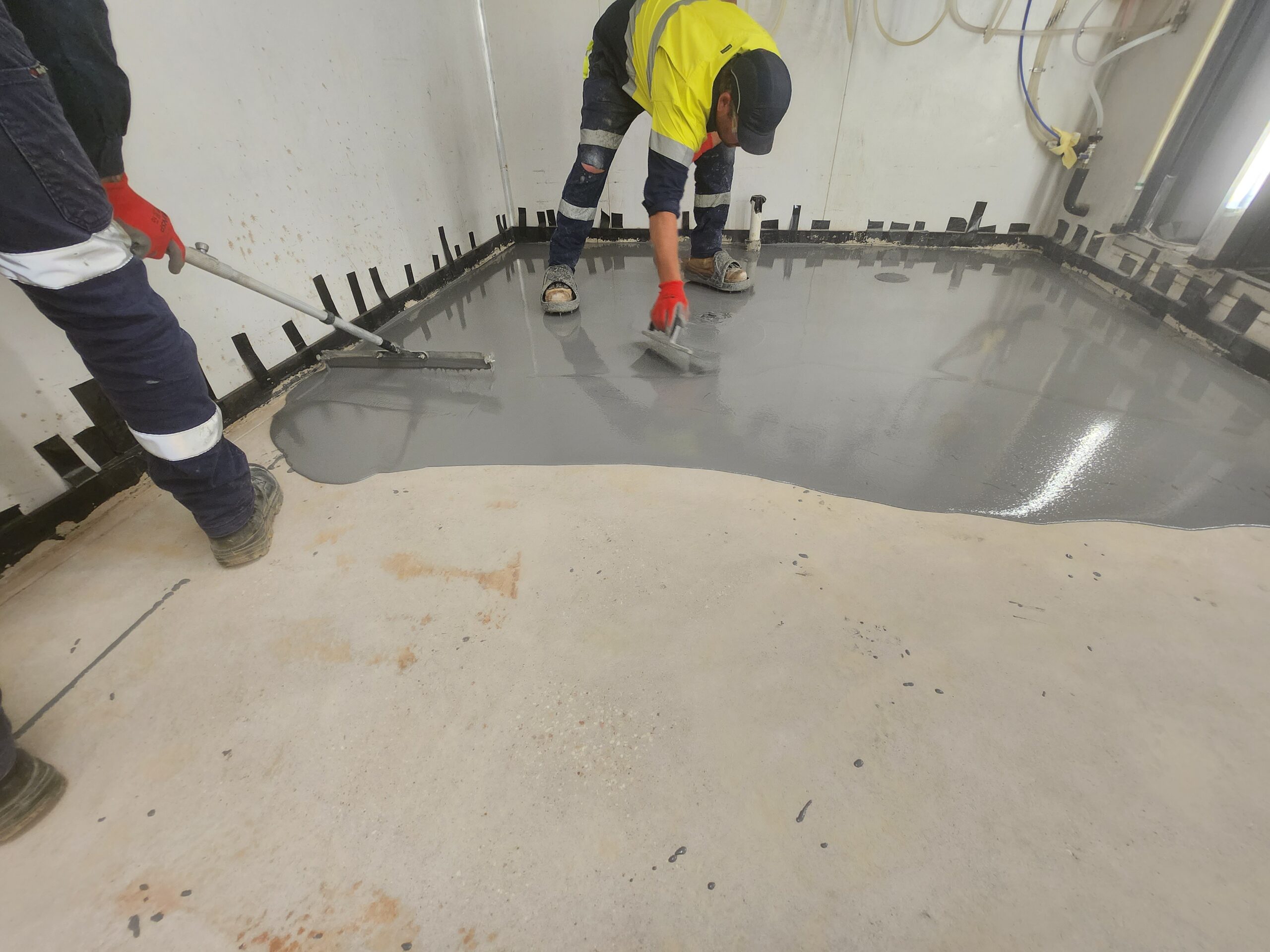 A man is working on the floor of a room.